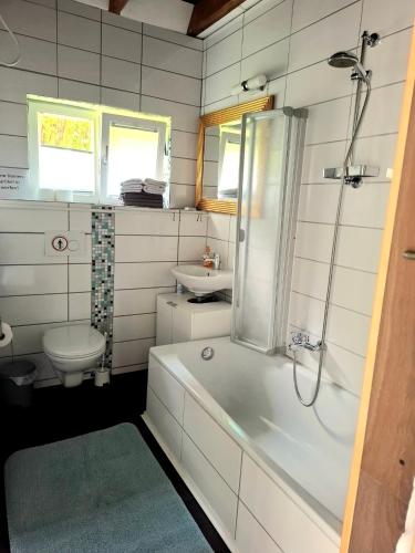 a bathroom with a tub and a toilet and a sink at Ferienhaus am Schulsee in Mölln