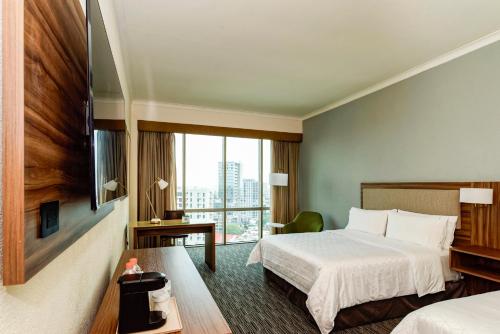 a hotel room with a bed and a window at Holiday Inn Guadalajara Select by IHG in Guadalajara