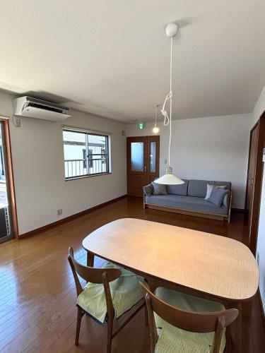 a living room with a table and a couch at Flat Dazaifu in Dazaifu