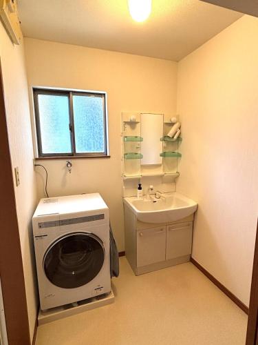 a laundry room with a washing machine and a sink at Flat Dazaifu in Dazaifu