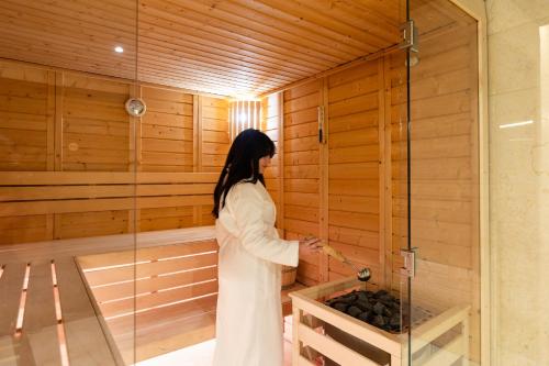 a woman is standing in a sauna at Hôtel & Spa Rocabella in LʼÎle-Rousse