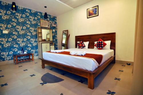 a bedroom with a bed and a blue and white wall at Royal Sundarban Wild Resort in Jharkhali