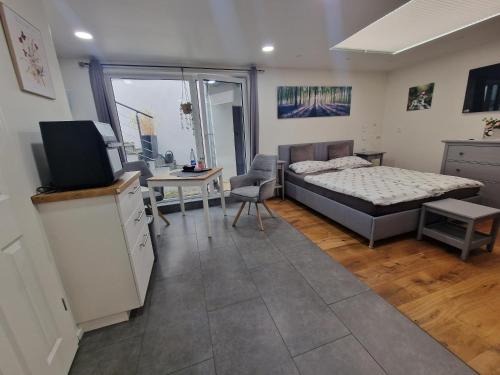 a bedroom with a bed and a desk and a television at Apartment am Rathaus in Heimbach