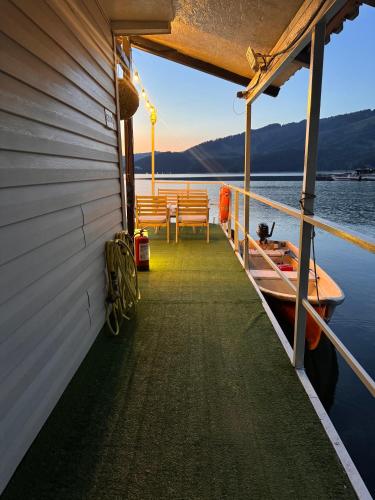 a boat dock with benches on the water at Casa pe lac Bicaz in Bicaz