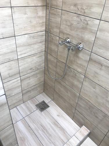 a shower with a glass door and a tile floor at Nice Big House in Balatonfenyves