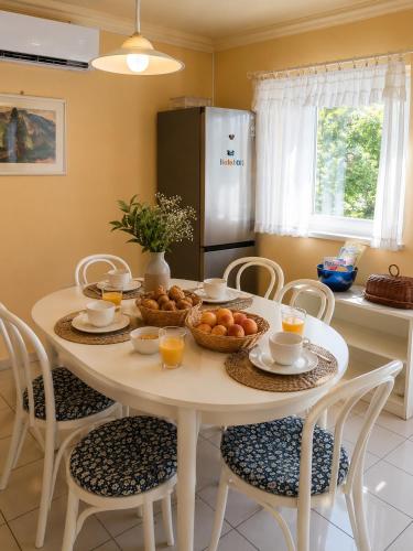 a kitchen with a table with a bowl of fruit on it at Margaréta Apartman in Balatonudvari