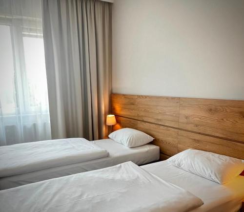 two beds in a hotel room with a window at NOVY Hotel in Zielona Góra