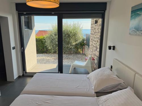 a bedroom with a bed and a large window at Villa Nina in Šmrika