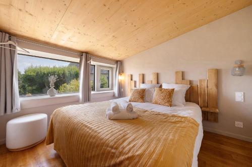 a bedroom with a large bed with a large window at La villa Grand Ouest in Plounéour-Trez