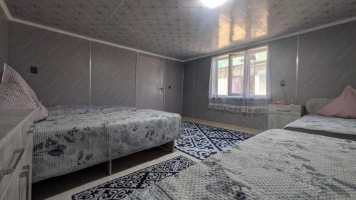 a bedroom with two beds and a window at Koch Iz guest house in Kochkorka