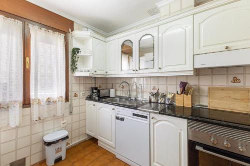 a kitchen with white cabinets and a sink at La Casona de Sacramenia in Sacramenia