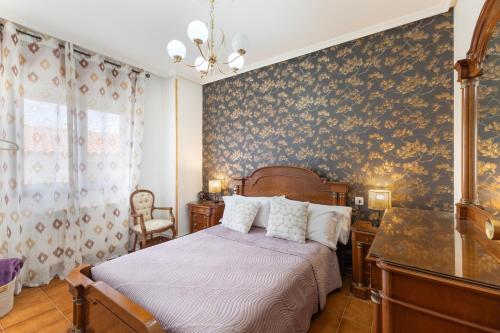 a bedroom with a bed and a wall covered in wallpaper at La Casona de Sacramenia in Sacramenia