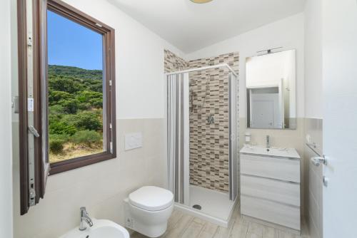 a bathroom with a toilet and a sink and a window at NRH Cannigione Sunrise Rooftop in Cannigione