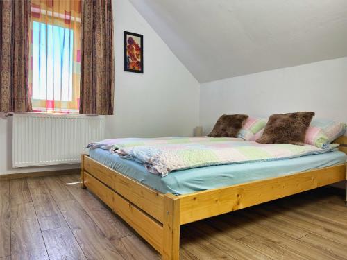 a wooden bed in a room with a window at Cabana 84 in Beclean