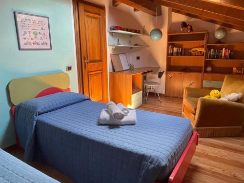 a bedroom with a blue bed and a desk at Casa Cadore Grea in Grea