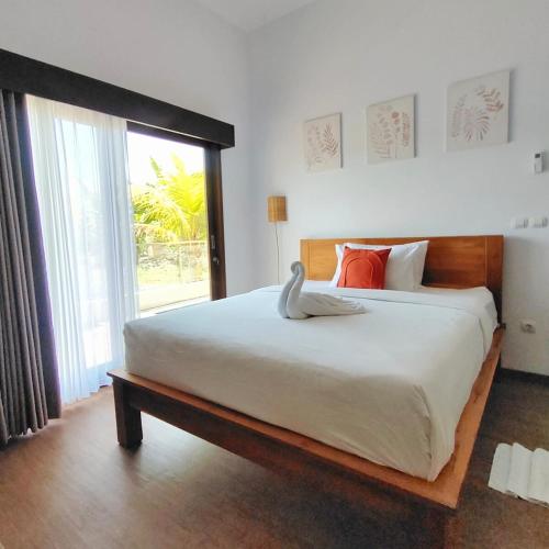 a bedroom with a large bed with a large window at Canggu Rice Field Villa 8B in Dalung