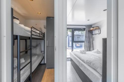 a room with two bunk beds and a window at Houseboat Marina Mookerplas on the Water | 4 - 6 people in Middelaar