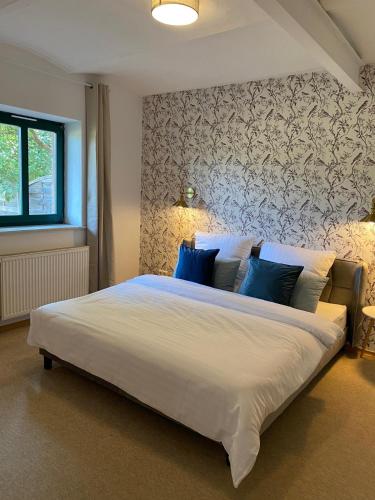 a bedroom with a large white bed with blue pillows at Smeers Hof in Böhme