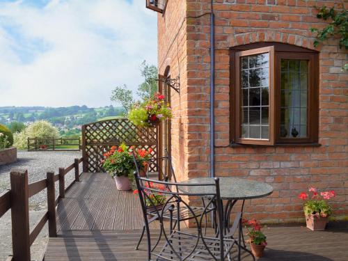 a patio with a table and chairs on a brick building at Y Bwthyn-Uk31367 in Tregynon