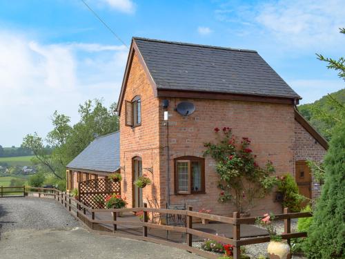 a small brick house with a wooden fence at Y Bwthyn-Uk31367 in Tregynon