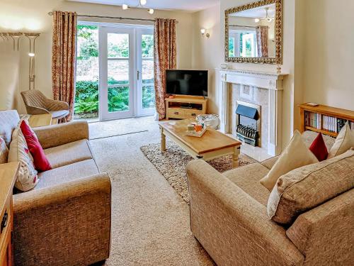 a living room with two couches and a television at 2 Greta Grove House in Keswick