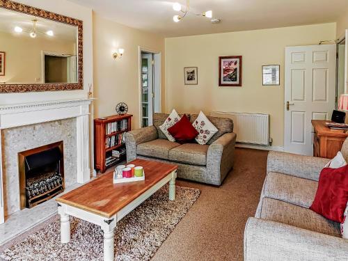 a living room with two couches and a fireplace at 2 Greta Grove House in Keswick