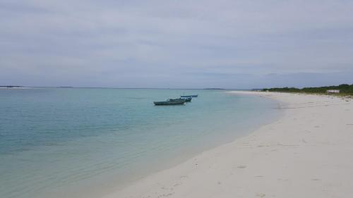 two boats sitting in the water on a beach at Nolhi Escape in Nolhivaranfaru