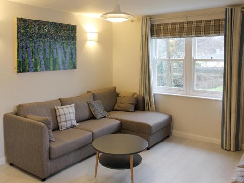 a living room with a couch and a table at 12A Elm Court in Keswick