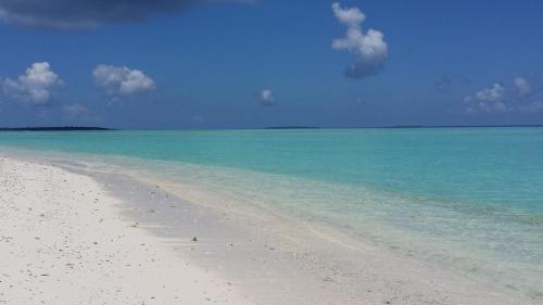 a beach with the ocean and blue water at Nolhi Escape in Nolhivaranfaru