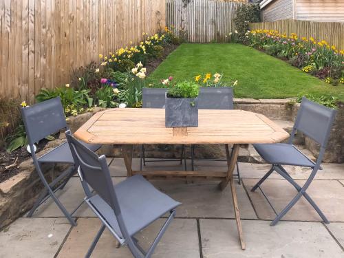 a wooden table and chairs in a garden at Little Plumtree in Addingham