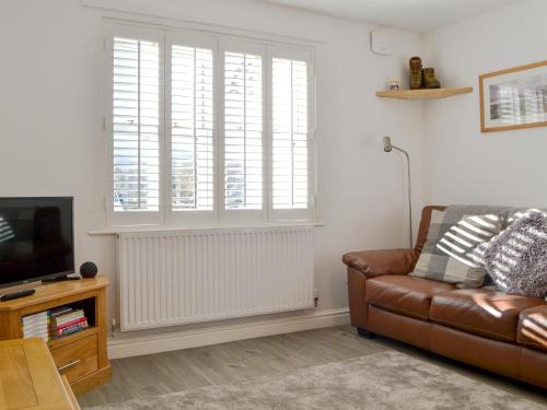 a living room with a couch and a large window at Wise Cottage in Keswick
