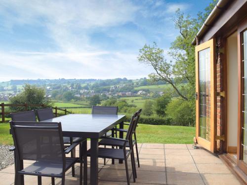 a table and chairs on a patio with a view at Talog Barn-Uk31366 in Tregynon