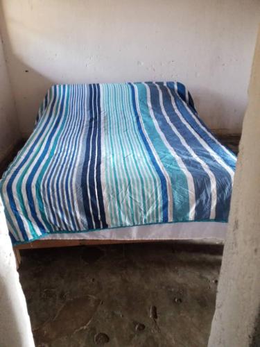 a blue and white striped bed in a room at Mabuu Drive Inn in Waya