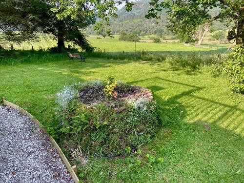 a park with a bench in a grass field at The Prince - Uk42204 in Clachan of Glendaruel