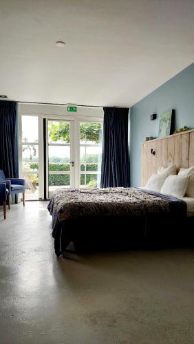 a bedroom with a bed and a large window at Erve 't Hacht in Ane