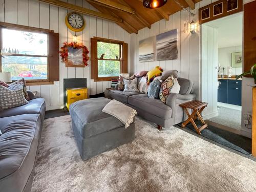 a living room with two couches and a clock at Willow's Rest in Crafthole