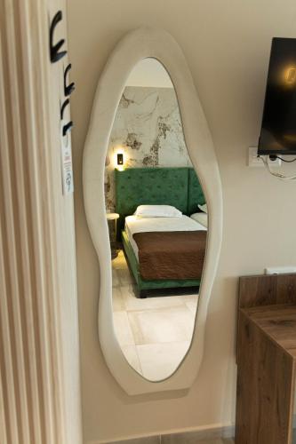 a mirror on a wall in a room with a bed at Hotel Central in Sunny Beach