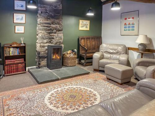 a living room with a couch and a fireplace at Little Knott in High Nibthwaite