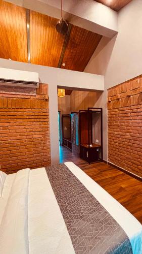 a bedroom with a bed in a room with wooden floors at Hide Away Resort in Jhārgrām