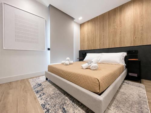 a bedroom with a large bed with white pillows at Garibaldi Suite 2 Renovated 1BR with Parking, Old Town Olbia in Olbia