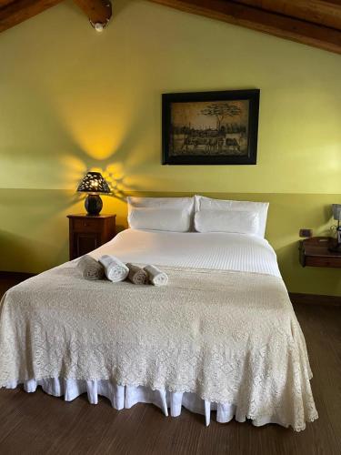 a bedroom with a white bed with towels on it at B&B Casa del Bosco in San Michele al Tagliamento