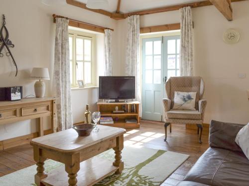 a living room with a couch and a tv at Broad Leaf - Iok in Brandesburton