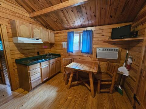a kitchen with a table and a stove in a cabin at Baraboo RV Resort in Baraboo