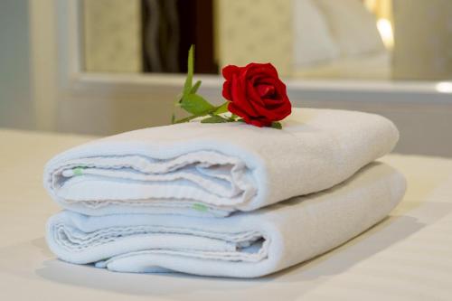 a stack of towels with a rose on top at The Ring Hotel in Hat Yai
