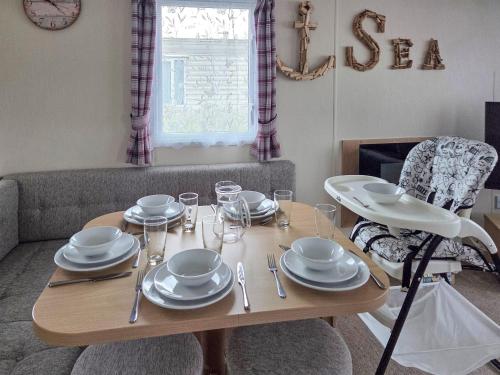 a dining room table with plates and glasses on it at Waterlily in Lancaster