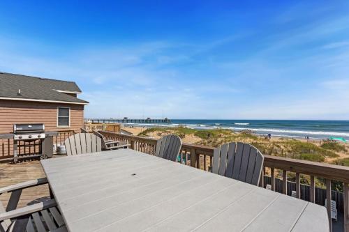 a wooden deck with a table and chairs and the beach at 7000 - Serenity Sands in Whalebone