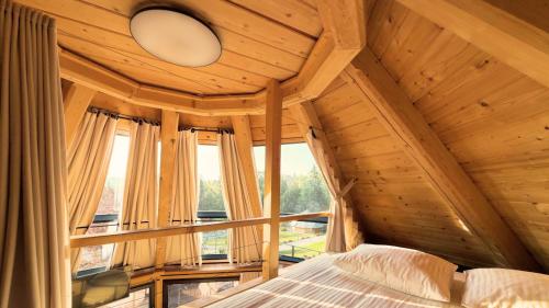 an attic bedroom with a bed and a window at Osada Poli Koniaków - Panoramiczny Domek nr 2 z Prywatną Balią i Hydromasażem in Koniaków
