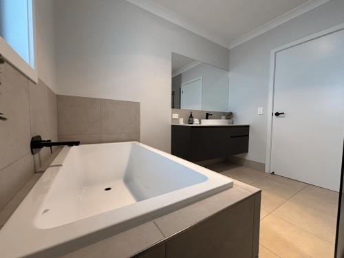 a large white bath tub in a bathroom at Wyoming Ave in North Wagga