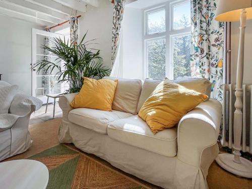 a living room with a white couch with yellow pillows at Gara Mill Cottage in Kingsbridge