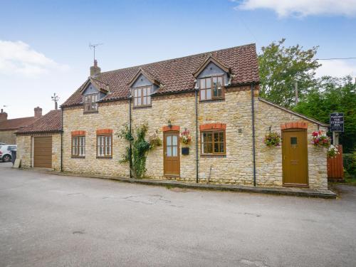 a brick house with brown doors and windows at The Stirrup Cottage in Blyborough